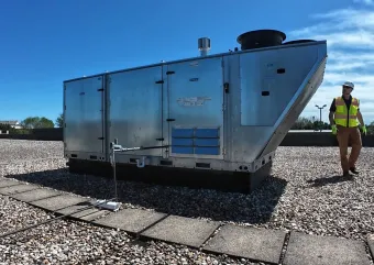 A contractor walking around a HVAC unit. 