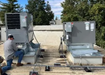 A HVAC technician performing maintenance on a commercial HVAC system. 