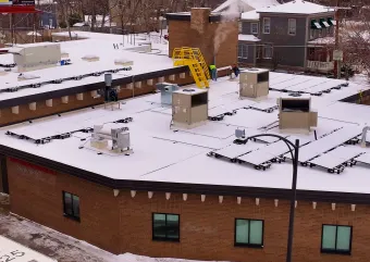 A building with fresh snow and rooftop units. 